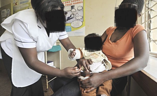 Healthcare worker assisting mother and child for health system improvement.
